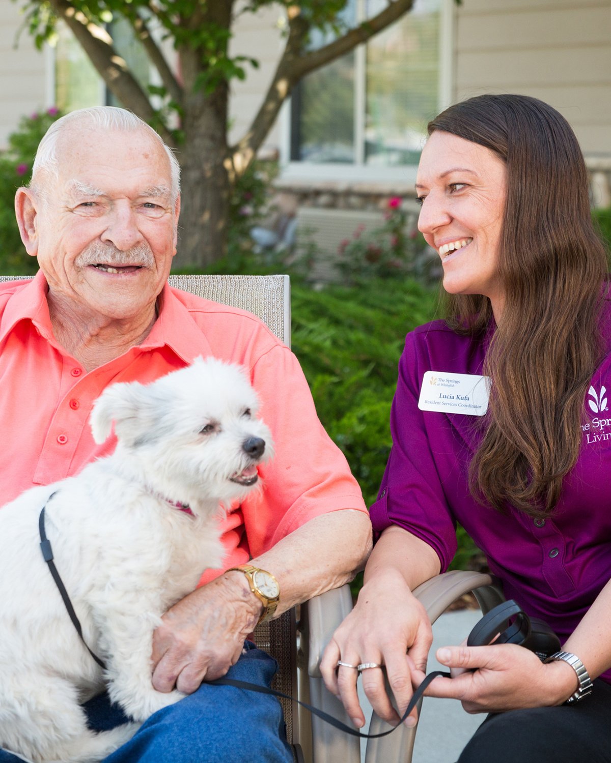 Older man and younger woman sit and laugh