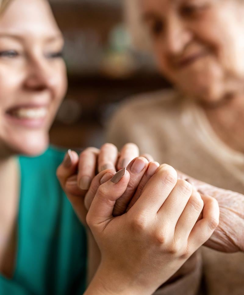 care provider holding seniors hands